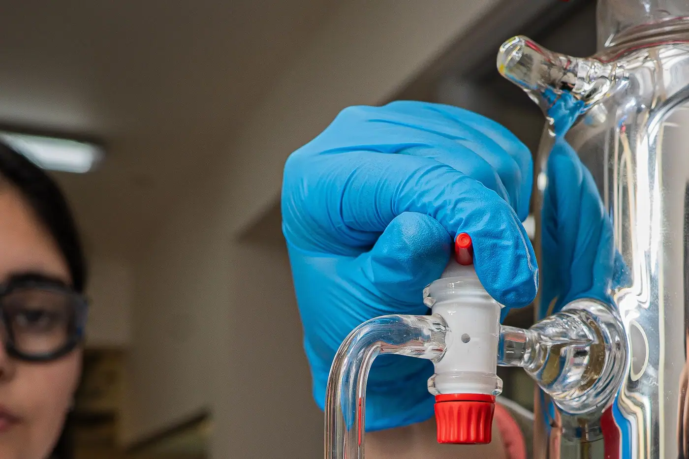 Scientist adjusting glass distillation apparatus inside a laboratory